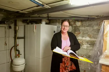 Frau Aiple blättert im Heizungsraum in Unterlagen.