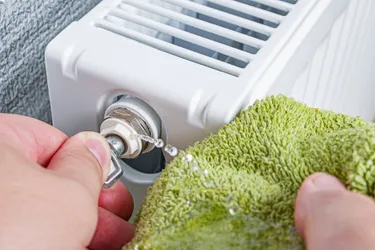 Nahaufnahme eines Heizkörpers, der gerade entlüftet wird