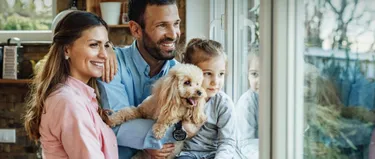 Familie steht vor dem Fenster
