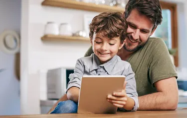 Vater und Sohn schauen gemeinsam auf ein Tablet
