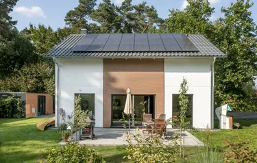 Nahaufnahme eines SchwörerHauses mit auf dem Dach installierter PV-Anlage.