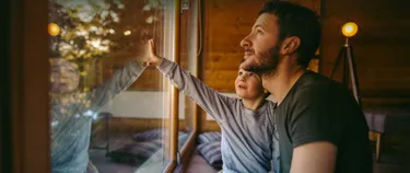 Vater und Kind schauen aus dem Fenster