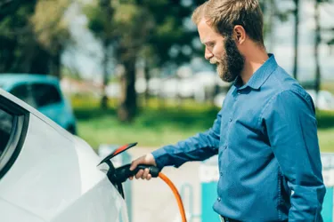 Ein Mann lädt sein E-Auto.