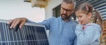 Vater mit Tochter vor einer Photovoltaikanlage