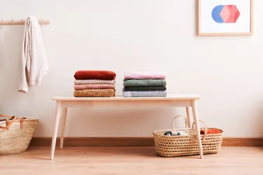 Bei einem minimalistischen Einrichtungsstil werden wenige Möbel in Szene gesetzt: Das Bild zeigt einen aufgeräumten Abstelltisch mit zusammengelegter Wäsche.