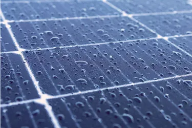 Nahaufnahme von Solarmodulen auf denen Regentropfen liegen