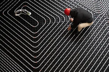 Ein Handwerker installiert eine Fußbodenheizung