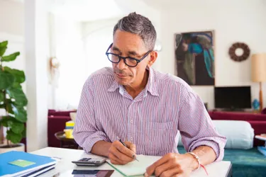 Ein Mann rechnet am Laptop sitzend seine Gesamtenergiekosten aus