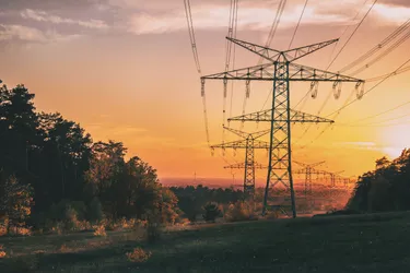 Eine Landschaft mit Stromtrasse bei Sonnenuntergang
