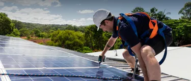 Solarpower für Energiewende: Das Bild zeigt einen Solarmonteur mit Akkuschrauber auf einem Gebäudedach.