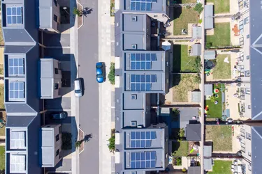 Ansicht eines Wohnviertels von oben in dem alle Dächer der Häuser mit einer Solaranlage ausgerüstet sind.