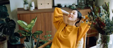 Eine Frau entspannt sich in ihrem Wohnzimmer.