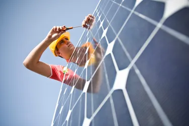 Nahaufnahme eines Handwerkers, der ein Solarmodul installiert