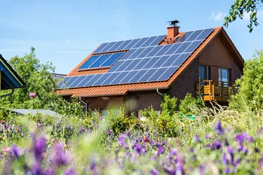 Nahaufnahme eines Einfamilienhauses mit auf dem Dach installierter PV-Anlage.