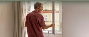 Mann öffnet ein Fenster