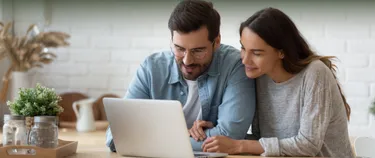 Ein Paar errechnet seinen Stromverbrauch am Laptop.