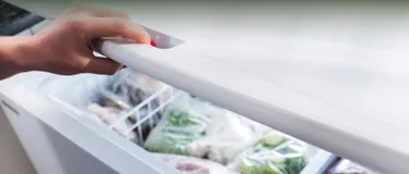 Blick in eine geöffnete Gefriertruhe, in der Gemüse und andere Tiefkühlkost ordentlich verpackt gelagert wird.