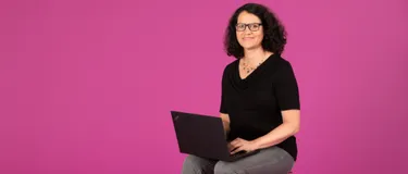 Dieses Bild zeigt Silvia Hoppe, die einen Laptop in der Hand hält.