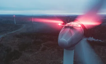 Nahaufnahme des Daches der Gondel einer Windkraftanlage auf der gerade ein Leuchtsignal aktiviert ist
