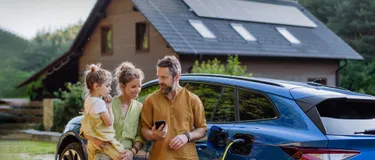 Familie vor Haus und Auto