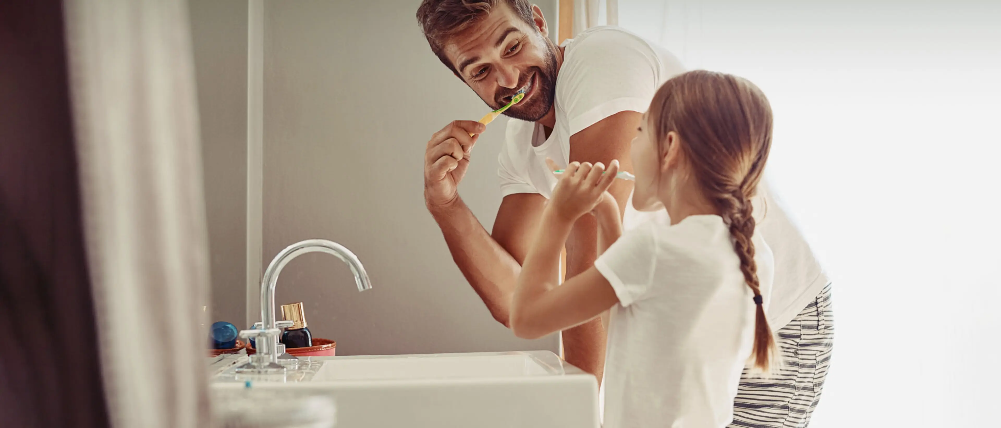Ein Vater und seine Tochter putzen zusammen ihre Zähne.