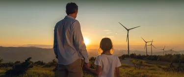 Vater und Kind schauen auf Windräder.