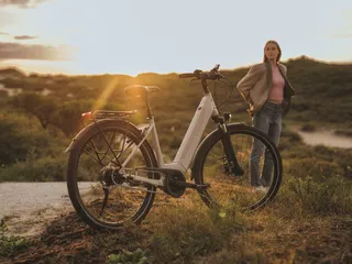 Fahrrad und Frau im Sonnenuntergang