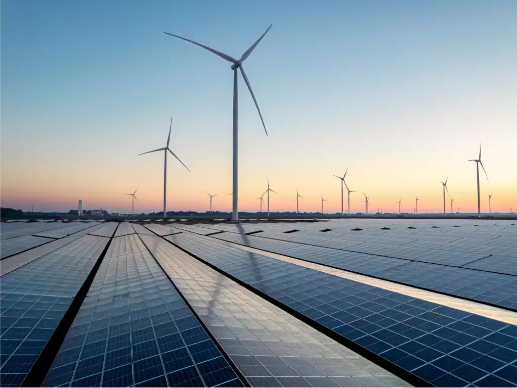 Im Vordergrund PV-Module, im Hintergrund Windräder.