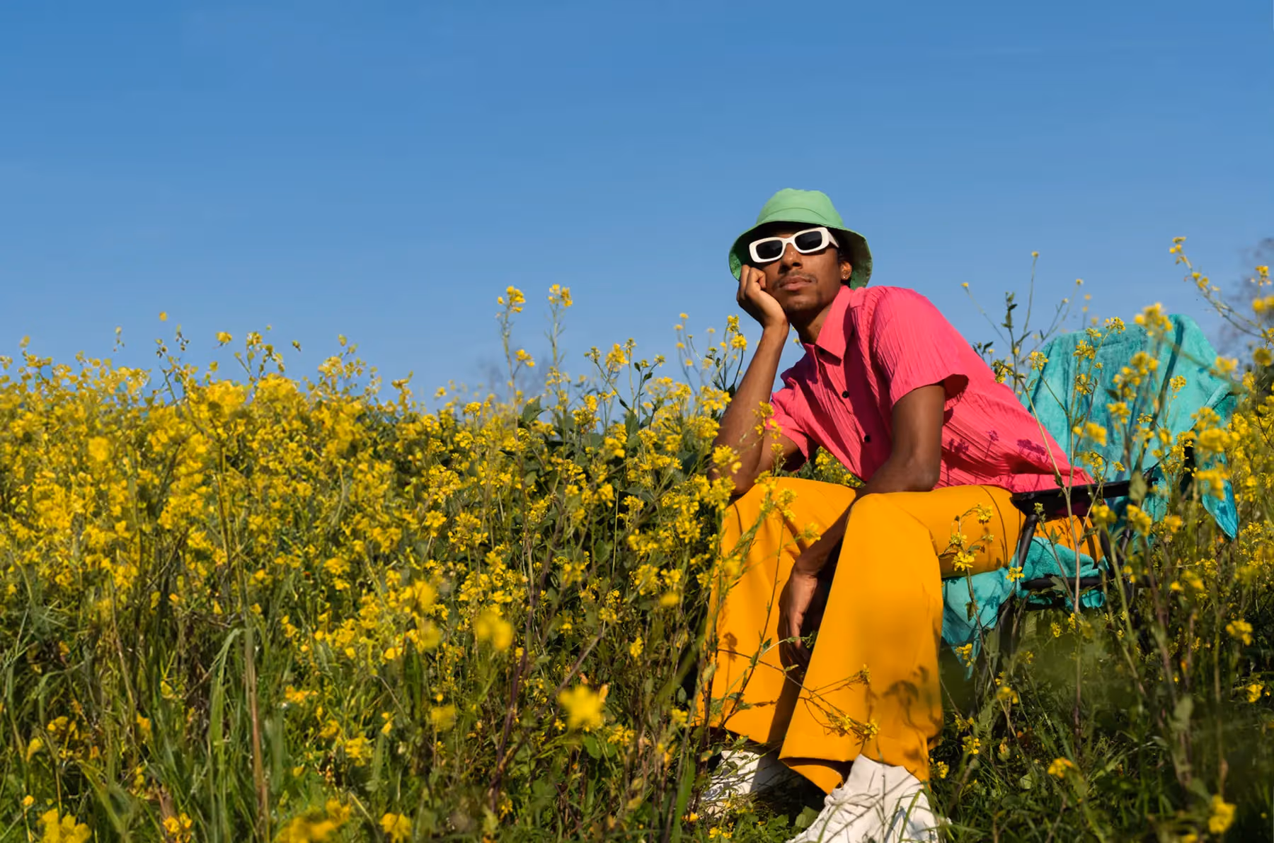 Person entspannt an einem sonnigen Sommertag in einer Blumenwiese